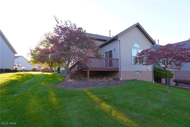 rear view of property featuring a deck and a lawn