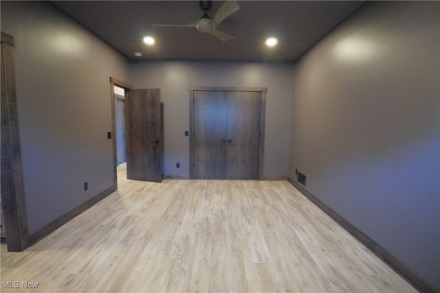 unfurnished bedroom featuring a closet, light wood-type flooring, and ceiling fan