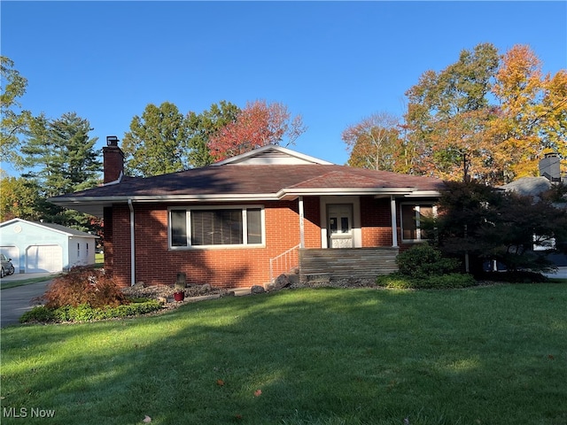 view of front of house featuring a front yard, an outdoor structure, and a garage