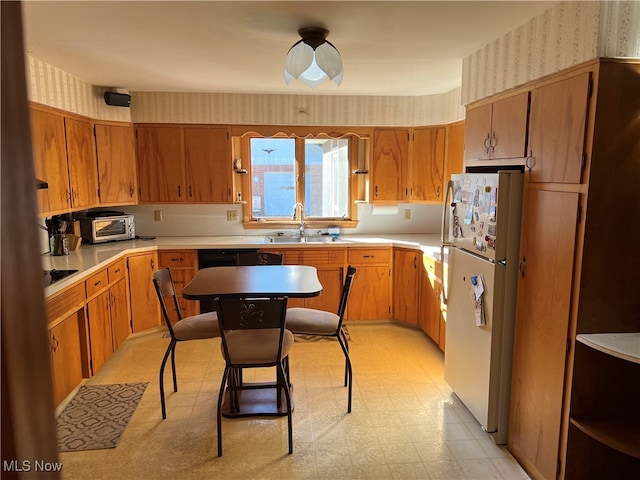 kitchen featuring sink, a breakfast bar, a center island, and white refrigerator