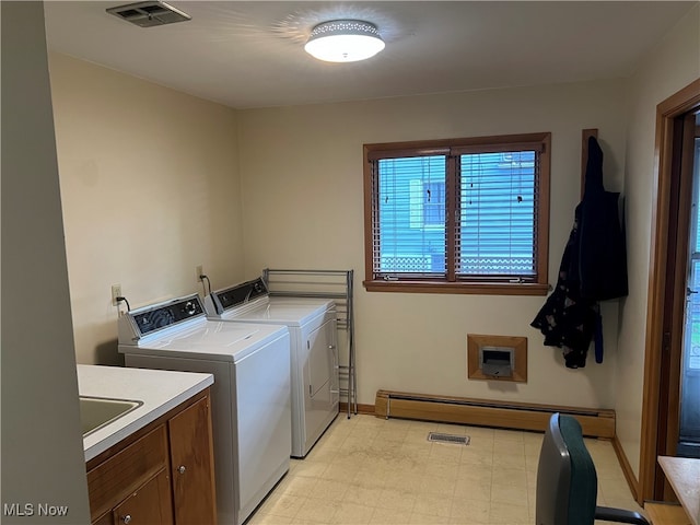 washroom featuring a baseboard heating unit, independent washer and dryer, and cabinets