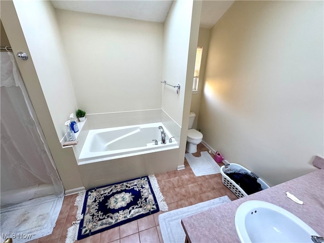 bathroom featuring toilet, vanity, tiled tub, and tile patterned floors