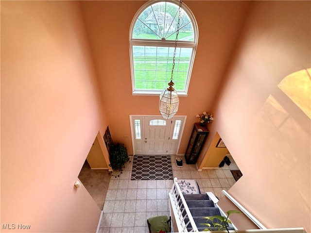 entrance foyer with light tile patterned flooring and a high ceiling