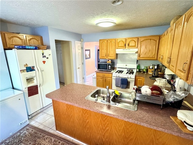 kitchen featuring kitchen peninsula, a textured ceiling, light tile patterned floors, and white appliances