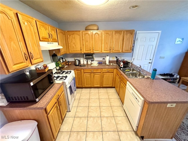 kitchen with sink, a textured ceiling, white appliances, and light tile patterned floors