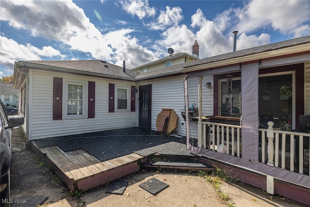 rear view of house featuring a wooden deck