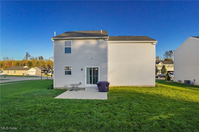 back of property with a yard and a patio