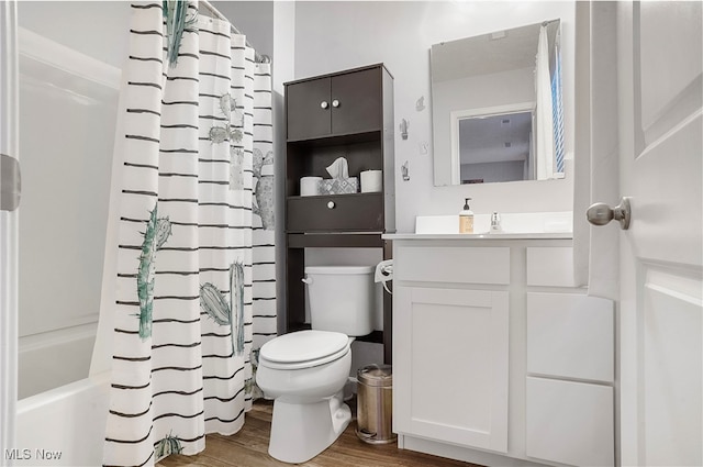 full bathroom with vanity, toilet, hardwood / wood-style flooring, and shower / bath combo with shower curtain