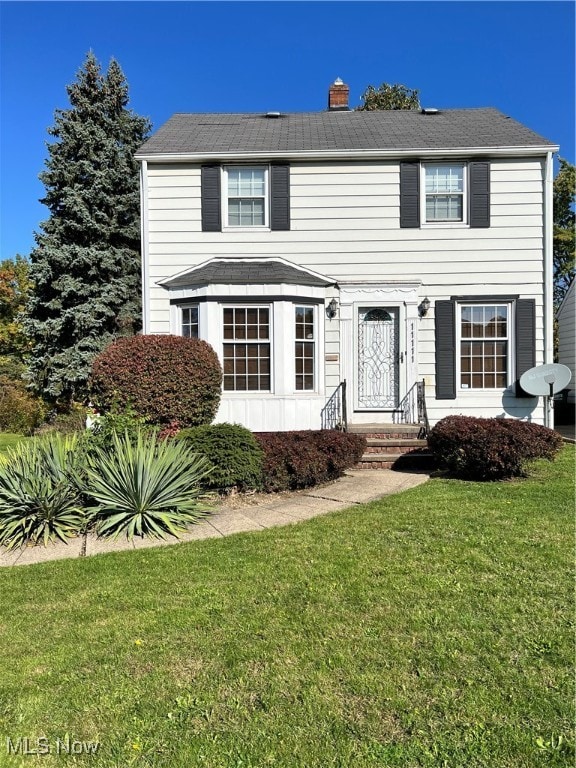 colonial inspired home featuring a front yard