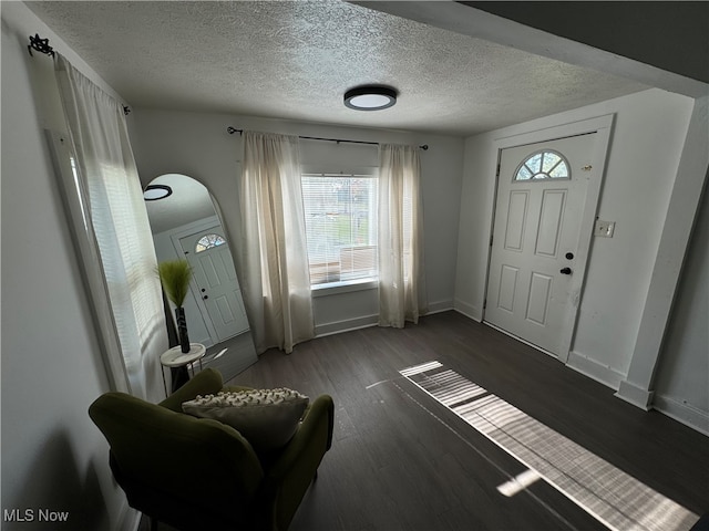 foyer entrance with a textured ceiling and dark hardwood / wood-style flooring