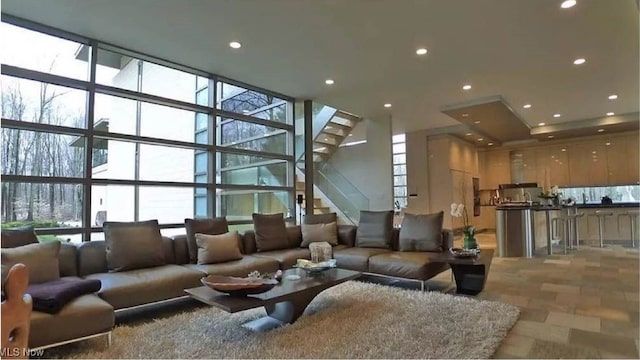 living room featuring a towering ceiling and a wall of windows