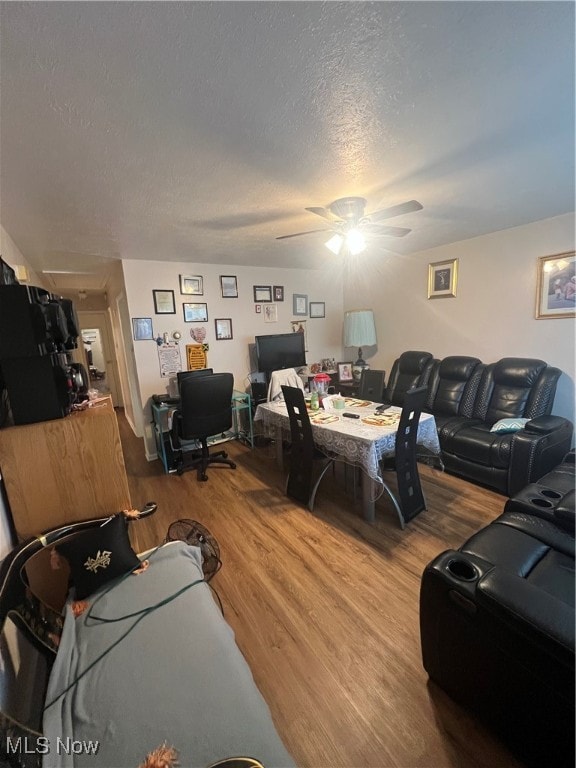 living room featuring a textured ceiling, hardwood / wood-style flooring, and ceiling fan