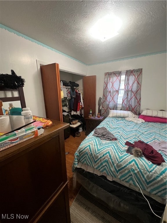 bedroom with hardwood / wood-style floors and a textured ceiling