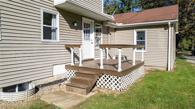 exterior space featuring a wooden deck and a lawn