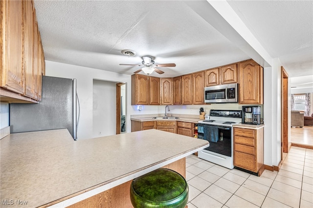 kitchen featuring fridge, sink, white electric range oven, a textured ceiling, and ceiling fan