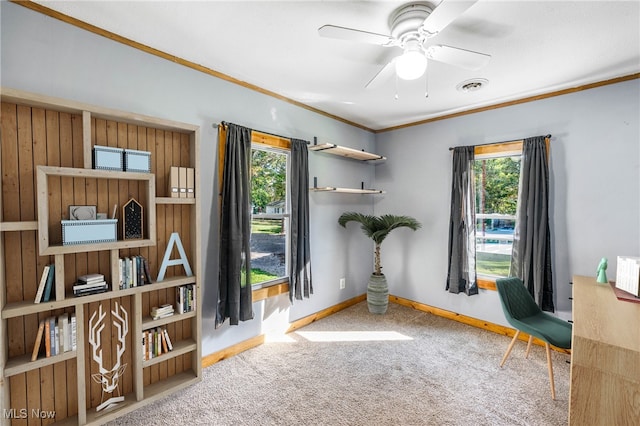 sitting room with crown molding, a healthy amount of sunlight, carpet, and ceiling fan