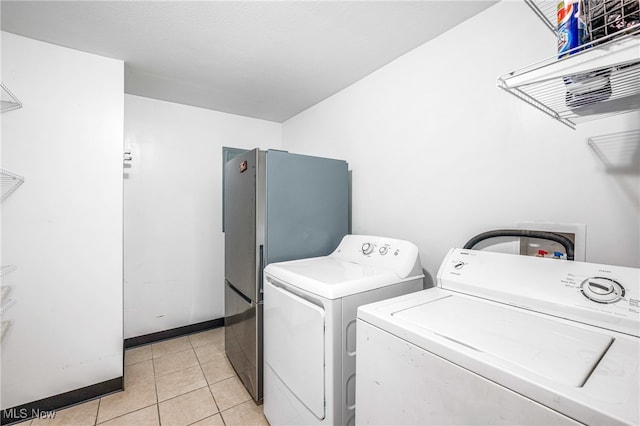 washroom with light tile patterned flooring and washer and clothes dryer