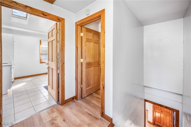 corridor featuring light hardwood / wood-style flooring and a skylight