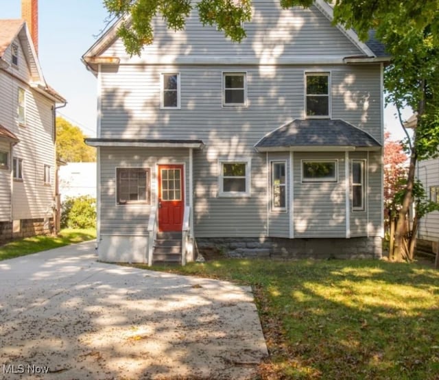 rear view of house featuring a yard