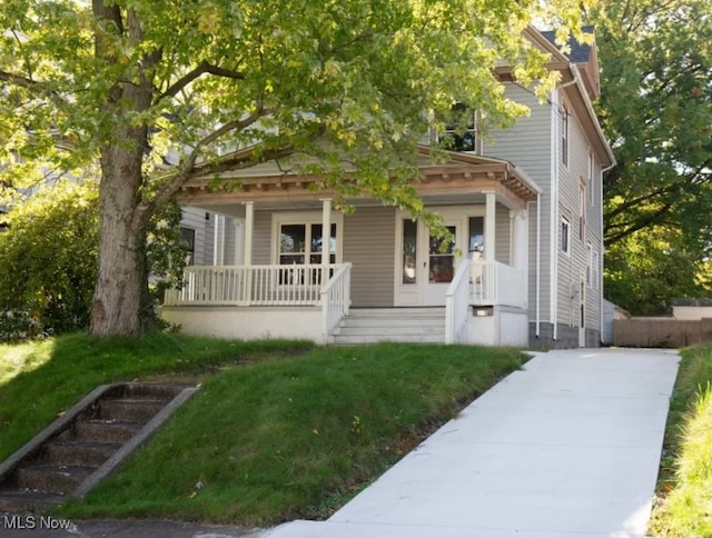 view of front of house featuring covered porch and a front yard