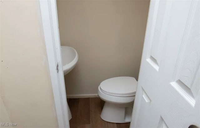 bathroom with toilet and hardwood / wood-style flooring