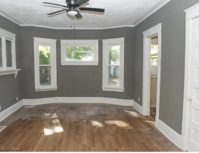 unfurnished room with crown molding, dark hardwood / wood-style flooring, and ceiling fan