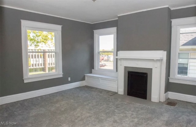 unfurnished living room with crown molding, a healthy amount of sunlight, and carpet