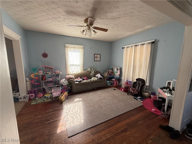 game room featuring a textured ceiling, wood-type flooring, and ceiling fan