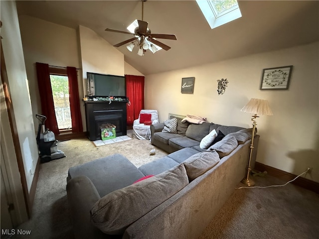 carpeted living room featuring ceiling fan, high vaulted ceiling, and a skylight