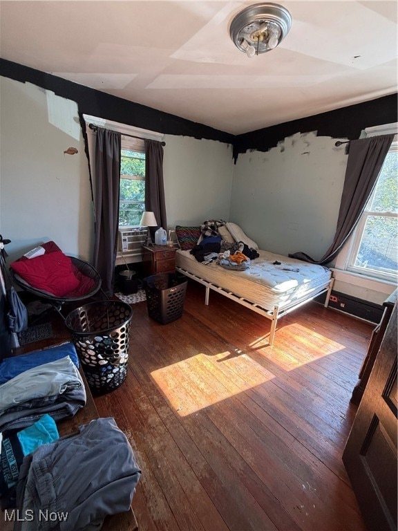 bedroom with cooling unit and hardwood / wood-style flooring