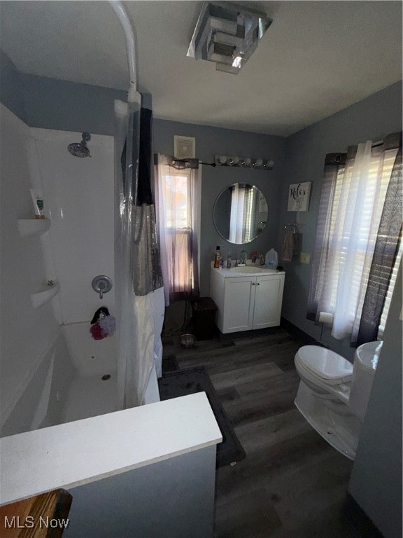 bathroom featuring vanity, toilet, a shower, and wood-type flooring