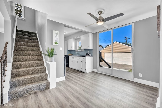 interior space featuring ceiling fan, sink, and light wood-type flooring