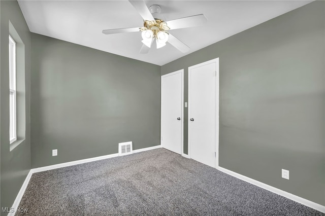 carpeted spare room featuring ceiling fan