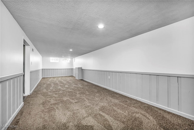 unfurnished room featuring a textured ceiling and carpet flooring