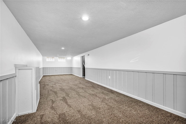 carpeted spare room featuring a textured ceiling