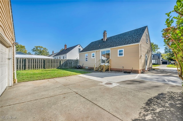 rear view of house with a lawn and a garage