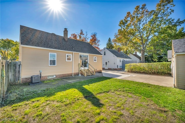 rear view of house featuring a patio area, a yard, and central AC unit