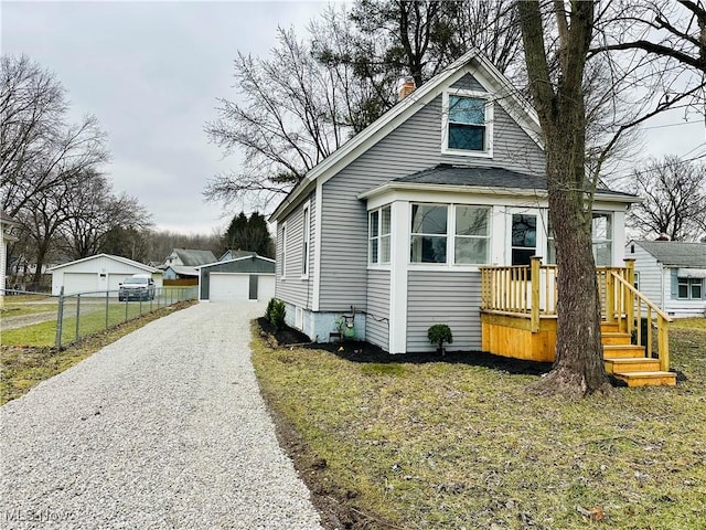 bungalow-style house featuring an outbuilding, a garage, and a front lawn