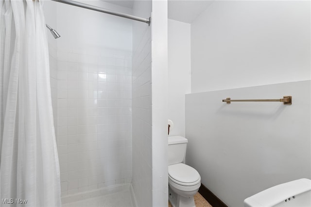 bathroom featuring toilet and curtained shower