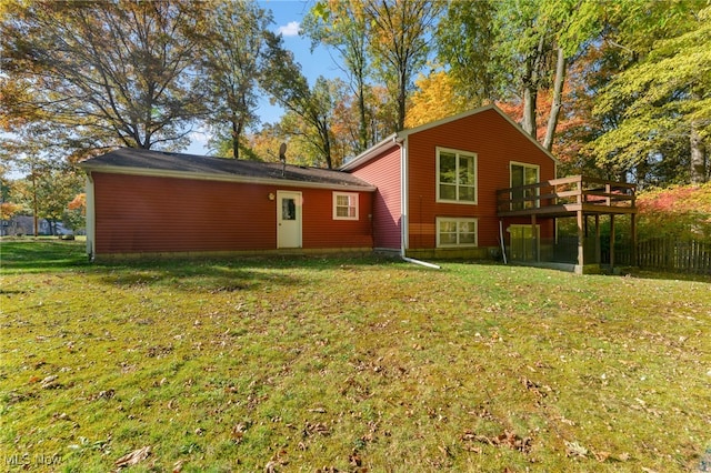 rear view of house with a wooden deck and a yard