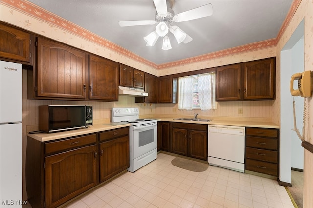 kitchen featuring ceiling fan, sink, dark brown cabinets, and white appliances