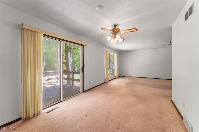 carpeted empty room featuring ceiling fan and a textured ceiling