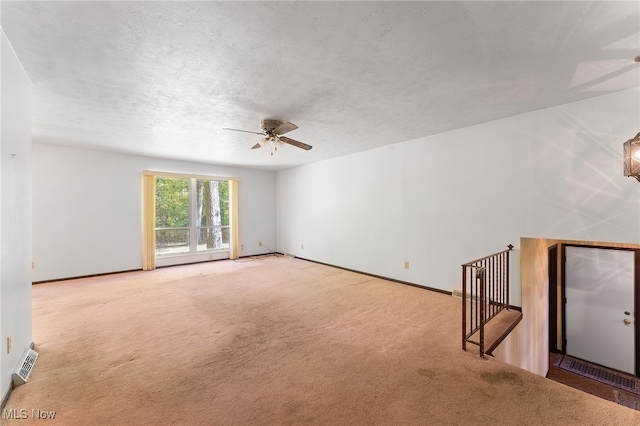 carpeted spare room with ceiling fan and a textured ceiling