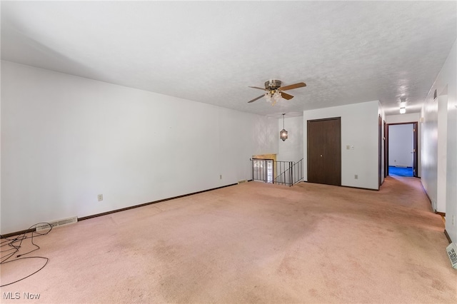 carpeted spare room featuring ceiling fan