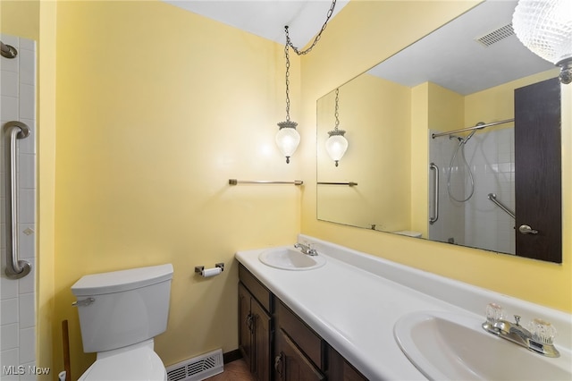 bathroom featuring a shower with door, toilet, an inviting chandelier, and vanity