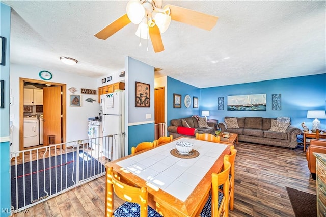 dining room with separate washer and dryer, hardwood / wood-style floors, and a textured ceiling