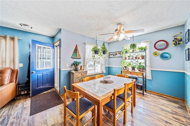 dining space with a textured ceiling, light hardwood / wood-style flooring, and ceiling fan