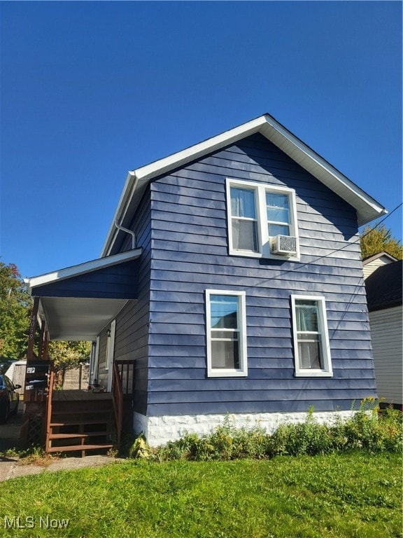 view of home's exterior with a wooden deck and a lawn