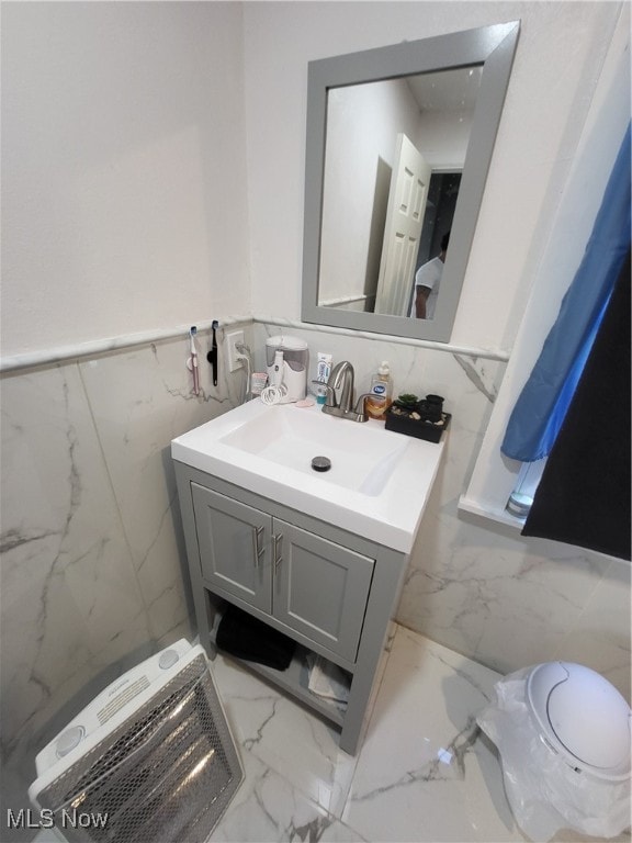 bathroom featuring vanity, toilet, and tile walls