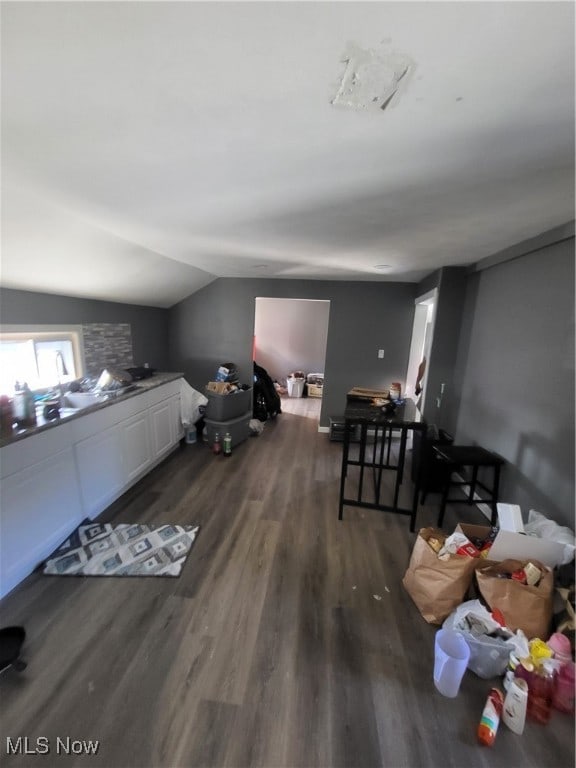 interior space with dark wood-type flooring and vaulted ceiling